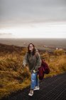 Жінка ходить на схилі пагорбів у похмурий день — стокове фото