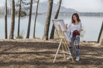 Молода жінка малює в сільській місцевості — стокове фото