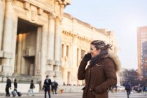 Jeune femme en vêtements d'hiver parlant au téléphone en plein air à Milan Italie — Photo de stock