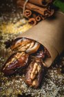 Halal snack for Ramadan with dried dates, figs and cinnamon wrapped in parchment — Stock Photo