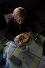 Da sopra donna anziana bere caffè da vetro a colazione mentre seduto a tavola — Foto stock