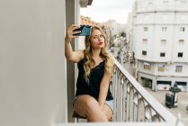 Jovem sorrindo mulher tomando selfie no terraço — Fotografia de Stock