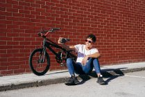 Giovane felice uomo nero scattare selfie con smartphone vicino alla bici — Foto stock