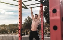 Junger Fitnessmann macht Klimmzüge im Freien — Stockfoto