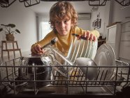 Boy with tools while repairing dishwasher in kitchen — Stock Photo