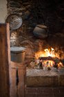 Удобная красивая кухня с камином и домашними хозяйствами, как сковорода и сетка старого теплого деревенского дома — стоковое фото