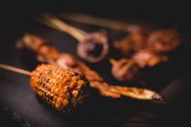 Delicious grilled hot skewers with natural corn, healthy mushrooms and meat on table in restaurant — Stock Photo