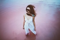 Giovane bella donna con lunghi capelli ricci indossa abito estivo godendo di brezza di mare — Foto stock