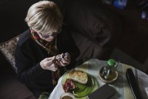 Старша приваблива жінка приймає ліки з пігулки перед сніданком — стокове фото