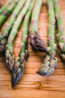 Closeup of bunch of fresh green asparagus on wooden surface — Stock Photo