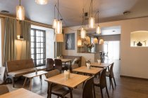 Elegante lampada splendente su tavolini e comode sedie in accogliente ristorante — Foto stock