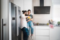 L'uomo barbuto che alimenta la fidanzata con cibo sano mentre trascorre del tempo in cucina a casa insieme — Foto stock