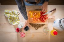 V tomar arándanos del frasco mientras se cocina alimentos saludables con vitaminas de frutas frescas en casa - foto de stock