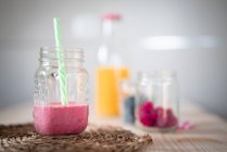 Envases con bayas frescas y bebidas saludables colocados en la mesa - foto de stock