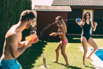 Freunde planschen mit Wasserpistolen — Stockfoto