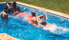 Men and women having fun in pool — Stock Photo