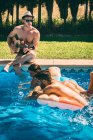 Hommes et femmes se détendre au bord de la piscine — Photo de stock