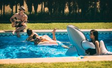 Мужчины и женщины отдыхают у бассейна — стоковое фото