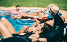 Uomini e donne rilassanti a bordo piscina — Foto stock