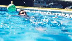 Hombre flotando en la piscina - foto de stock