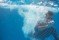 Молодой человек плавает под водой — стоковое фото