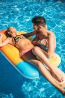 Jeune couple se reposant dans la piscine — Photo de stock