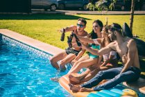 Freunde trinken Bier am Pool — Stockfoto