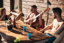 Guy playing guitar for his friends — Stock Photo