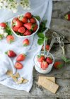 Dessert sucré crémeux aux fraises juteuses fraîches servi en verre sur table rustique en bois avec biscuits — Photo de stock