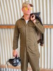 Selbstbewusster Pilot steht im Hangar und hält Helm — Stockfoto