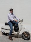 Hipster de meia-idade positivo em roupas elegantes com moto retro olhando para longe em dia ensolarado — Fotografia de Stock