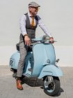 Hipster de meia-idade positivo em roupas elegantes com moto retro olhando para longe em dia ensolarado — Fotografia de Stock