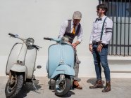 Позитивний гіпстери середнього віку в елегантному одязі з ретро мотоциклами, що дивляться у сонячний день. — стокове фото