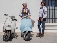 Позитивні хіпстери середнього віку в елегантному одязі з ретро мотоциклами, які дивляться в сонячний день — стокове фото
