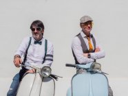 Positivi hipster di mezza età in abiti eleganti con moto retrò che distolgono lo sguardo nella giornata di sole — Foto stock