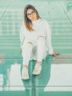 Giovane hipster femminile moderno in abiti casual su sfondo di occhiali geometrici guardando la fotocamera — Foto stock