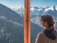 Anonyme Frau blickt aus Fenster auf Berge — Stockfoto