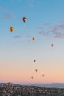 Balões de ar quente voando contra cume da montanha e céu ensolarado durante o festival na Capadócia — Fotografia de Stock