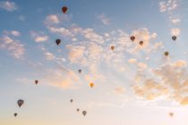 Воздушные шары, летящие против солнечного закатного неба во время фестиваля в Каппадокии — стоковое фото