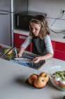 Kleines Mädchen wäscht Teller über Spüle in Küche zu Hause — Stockfoto