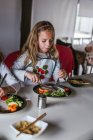 Дівчата насолоджуються смачною локшиною з вегетаріанськими котлети та овочі, сидячи за столом вдома — стокове фото