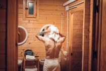 Mann steigt aus der Dusche und trocknet sich die Haare mit dem Handtuch — Stockfoto