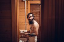 Uomo barbuto lavarsi i denti in casa di legno — Foto stock