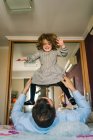 Faceless papà avendo divertimento con felice figlia holding su mani mentre sdraiato su letto — Foto stock