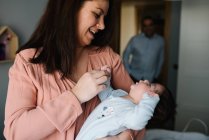 Brunette mom hugging cute little baby looking away at home — Stock Photo