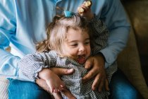 Father hugging cute little girl looking away and having fun at home — Stock Photo