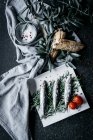Солоні анчоуси розміщені на купі гілочок розмарину біля тканинної серветки з оливковими гілками і свіжим хлібом — стокове фото