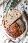 Зверху домашній свіжий хліб з кислинкою в скатертині на дерев'яному столі — стокове фото