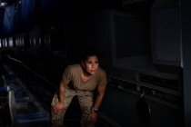 Fuerte soldado femenino de pie dentro del transporte militar moderno - foto de stock