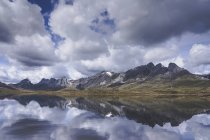 Nuvole bianche che galleggiano sulla cresta della montagna e la superficie calma del lago Embalse del Casares a Leon, Spagna — Foto stock